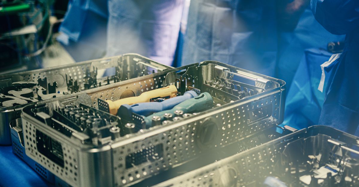 Close-up of sterilization trays containing surgical instruments in a medical setting.