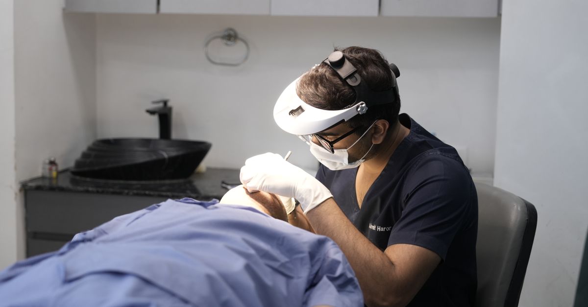 A dermatologist performing a procedure in a clinical setting in Delhi, India.