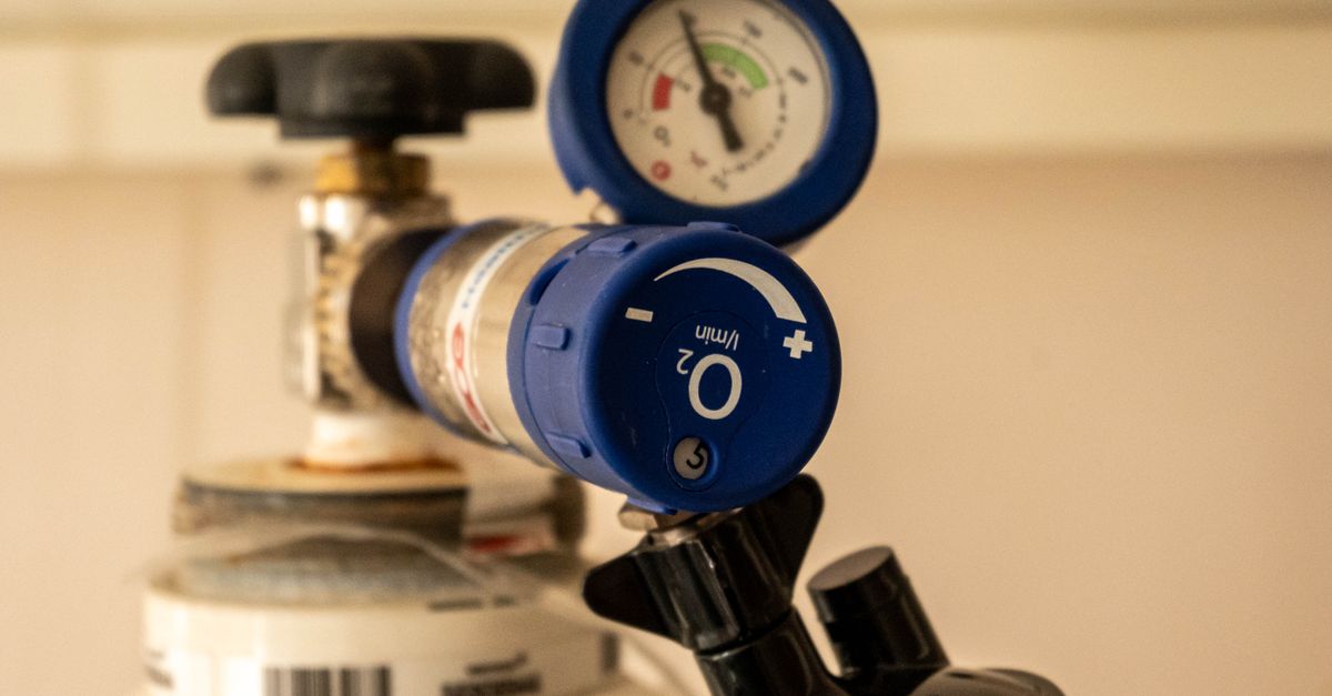 Detailed view of an oxygen tank with a pressure gauge, showcasing medical equipment usage.