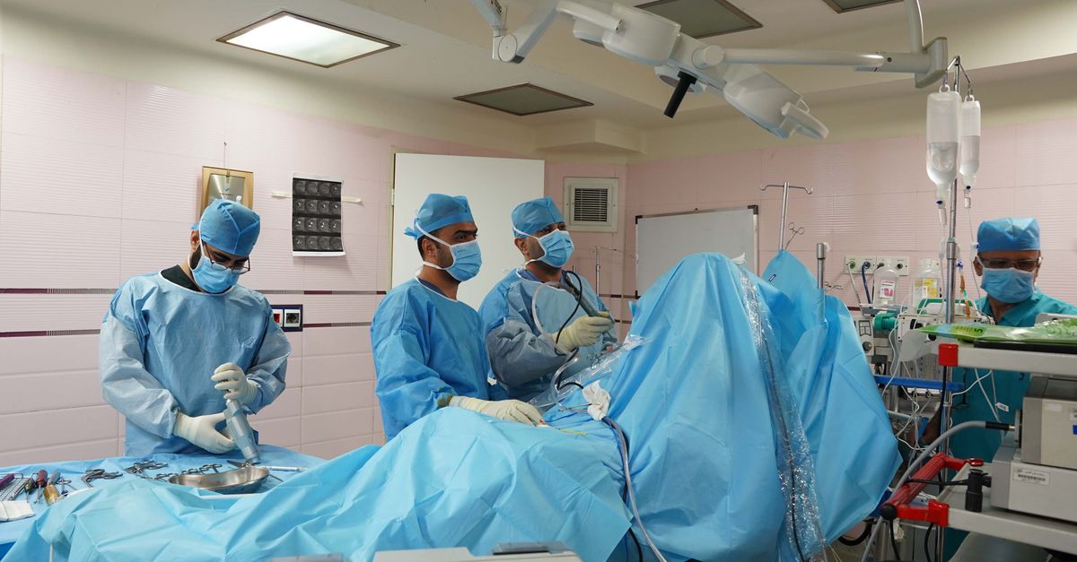 Doctors performing surgery in a hospital's operating room, utilizing medical equipment and surgical instruments.